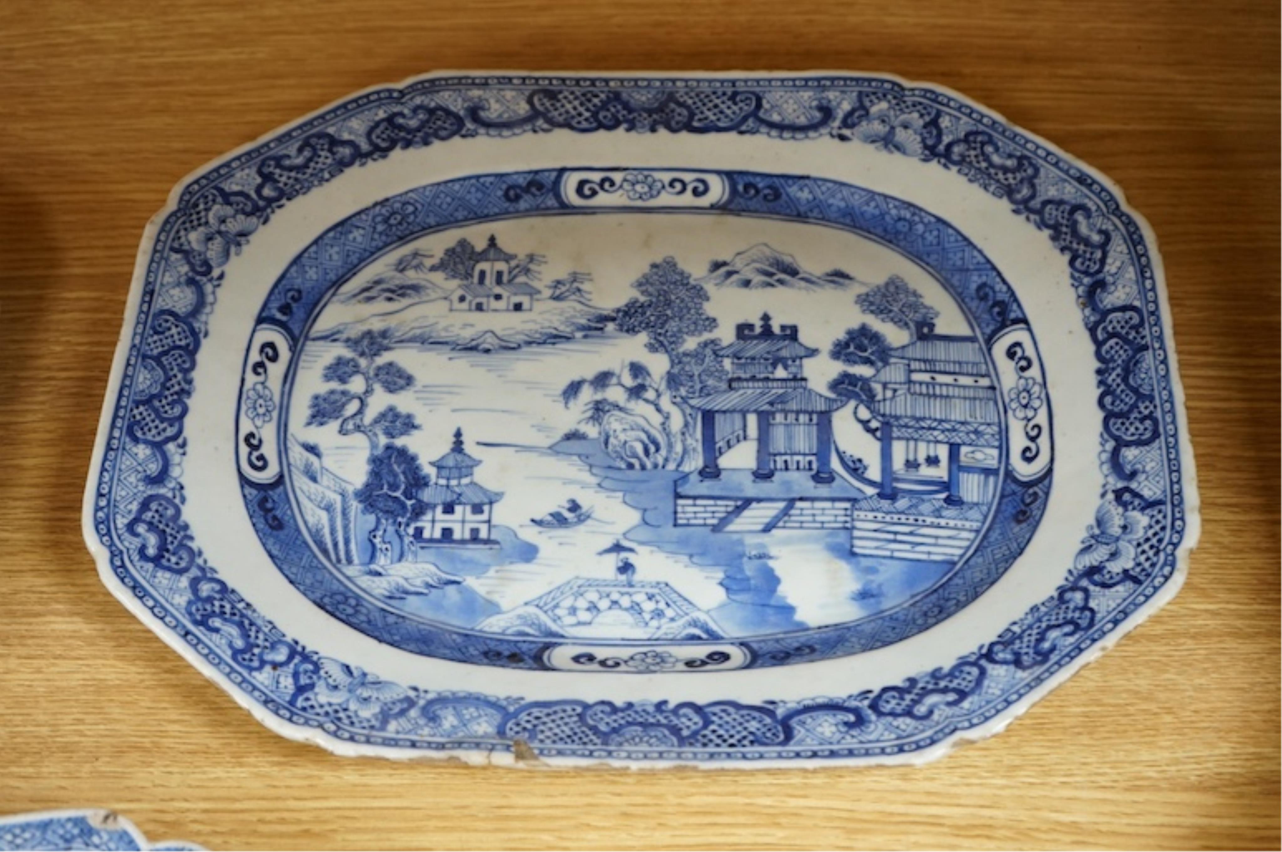 Three 18th century Chinese export blue and white dishes, two decorated with Lotus and peonies, the third with figures in a river landscape scene, Condition - fair to good